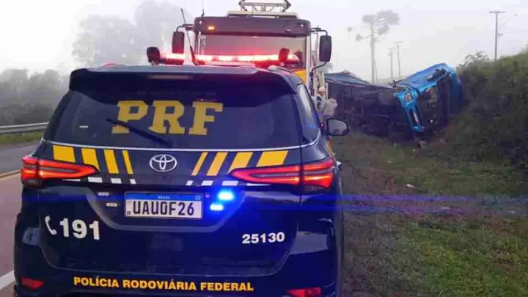 Caminhão carregado com biscoitos tomba em curva e motorista fica preso às ferragens